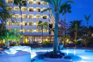 Piscina y Hotel de noche - Corallium Beach by Lopesan Hotels